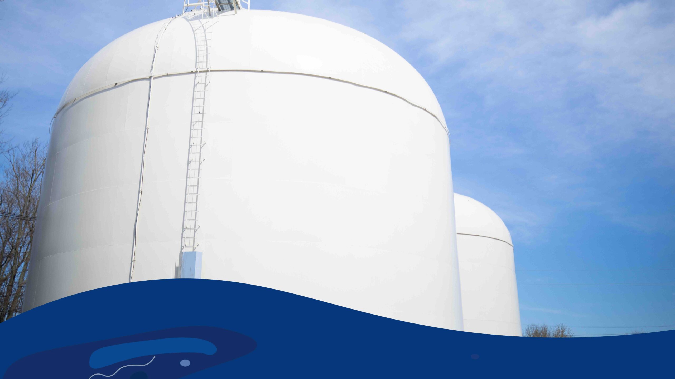 Image of a blue sky and industrial white water hold tanks